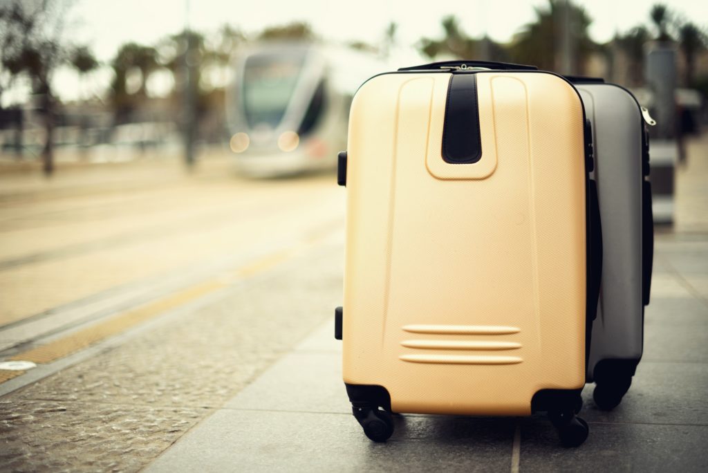 Citypass Light Rail in Jerusalem. Two suitcases standing on railway station against city train